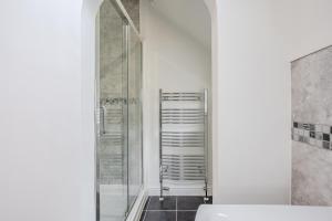 a bathroom with a shower and a towel rack at Esk Valley House in Sleights