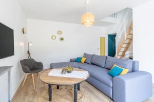 een woonkamer met een blauwe bank en een tafel bij Maison 12pers 3kms de la plage in Plozévet