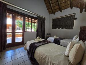a bedroom with two beds and a window at Glen Afric Country Lodge in Hartbeespoort