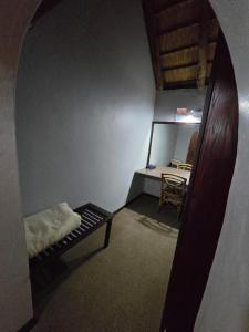 Cette chambre comprend un miroir, un lit et une table. dans l'établissement Glen Afric Country Lodge, à Hartbeespoort