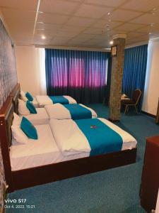 una camera da letto con un grande letto con cuscini blu e bianchi di Jiger Palace Hotel a Erbil