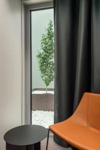 an orange chair and a table in front of a window at Citybox Tallinn City Center in Tallinn