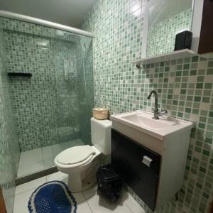 uma casa de banho com um WC, um lavatório e um chuveiro em Apartamento Com Piscina no Rio de Janeiro