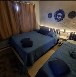 um quarto com 2 camas e lençóis azuis em Apartamento Com Piscina no Rio de Janeiro