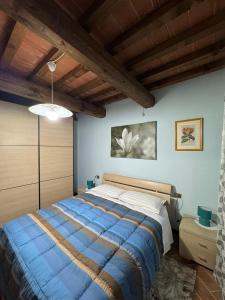 - une chambre avec un grand lit dans une pièce dotée de plafonds en bois dans l'établissement Appartamento con piscina Il Borghetto - vicino San Gimignano, à Gambassi Terme
