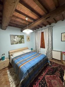 - une chambre avec un grand lit dans une pièce dotée de plafonds en bois dans l'établissement Appartamento con piscina Il Borghetto - vicino San Gimignano, à Gambassi Terme