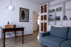 a living room with a blue couch and a table at Boutique Apartment Cà Monastero in Verona
