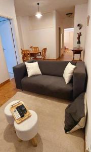 a living room with a black couch and a table at Pet friendly T1 sossegado c/ pátio espaçoso in Luanda