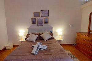 um quarto com uma cama com duas toalhas em Pet friendly T1 sossegado c/ pátio espaçoso em Luanda