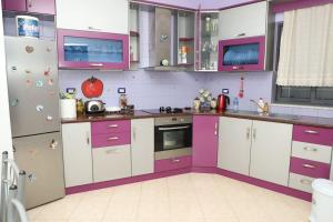 a kitchen with purple and white cabinets and appliances at Toni Apartment Berat in Berat