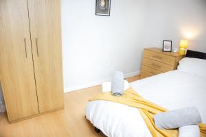 a bedroom with a bed and a wooden cabinet at Central 2 Bed Flat - Leeds City Centre - For Relocatlors, Professionals in Leeds