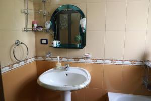 a bathroom with a sink and a mirror at Toni Apartment Berat in Berat +24 photos
