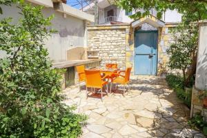 a patio with a table and chairs and a blue door at Toni Apartment Berat in Berat