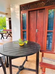 - une table en bois avec un bol à côté d'une porte dans l'établissement Ayur Nelum Villa, à Bentota