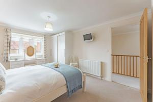 A bed or beds in a room at Avocet Cottage - Norfolk Cottage Agency