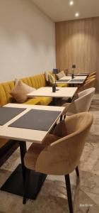 una fila de mesas y sillas en una habitación en Hotel Des Zouaves, en Koksijde