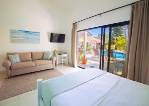 a bedroom with a bed and a living room at Garden By The Sea in Sosúa