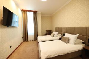 Habitación de hotel con 2 camas y TV de pantalla plana. en Hotel Vidović en Banja Luka