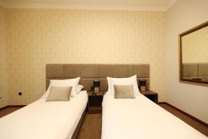 dos camas sentadas una al lado de la otra en una habitación en Hotel Vidović, en Banja Luka
