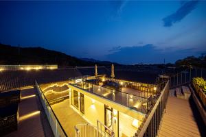 une maison avec des lumières sur la terrasse la nuit dans l'établissement 八达岭诚苑民宿, à Xibozi