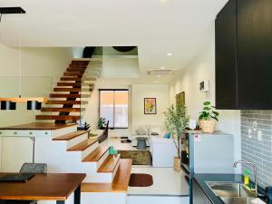 a kitchen and dining room with a staircase in a house at The Rooftop Townhouse in Center of Pattani in Kampong Rusamileh
