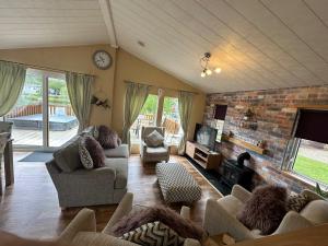 タターズホールにあるLuxury Lakeside Lodge L1 with hot tub situated at Tattershall Lakes Country Parkのレンガの壁のリビングルーム(ソファ付)