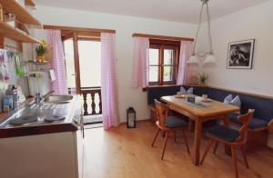 uma cozinha com uma mesa de madeira e uma sala de jantar em Ferienwohnungen „Zum Bauern“ em Oberaudorf