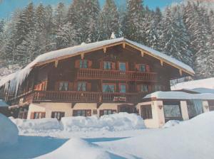 uma grande casa de madeira coberta de neve em Ferienwohnungen „Zum Bauern“ em Oberaudorf