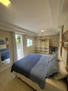 um quarto com uma cama com um edredão azul em Hotel Cantareira em Niterói