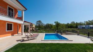 a backyard with a swimming pool and a house at Villa Nia with Private Pool in Karigador
