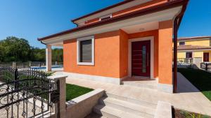 a small orange house with a purple door at Villa Nia with Private Pool in Karigador