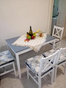 a table with a bottle of wine and fruit on it at Casa Mariella in Bari