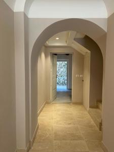 un couloir vide avec une arche dans une maison dans l'établissement Charme in Centro with private parking, à Ascoli Piceno