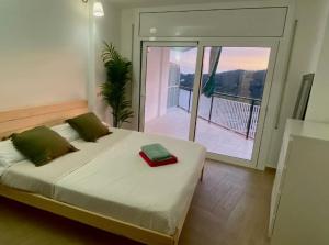Bett mit roter Box in einem Zimmer mit Balkon in der Unterkunft Piso con piscina in Arenys de Munt