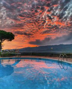 ein großer Pool mit Sonnenuntergang im Hintergrund in der Unterkunft Piso con piscina in Arenys de Munt