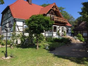 a large house with a red roof and a tree at Ferienwohnung Adolfshof 1 in Malente