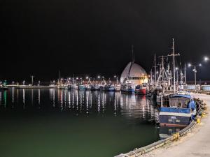 a group of boats docked in a harbor at night at White Shell Apartament Hel in Hel