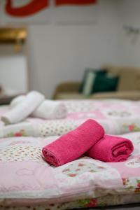 a pink towel laying on top of a bed at Apartamenty Czary Mary in Bardo