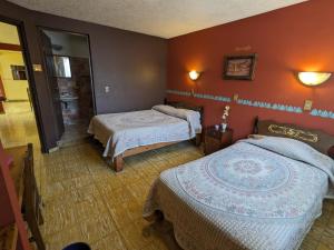 a hotel room with two beds and a bathroom at Hotel del Parque in Uruapan del Progreso