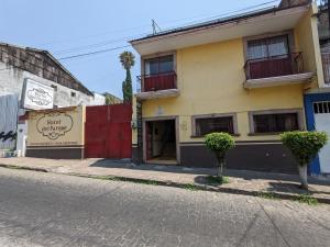 un bâtiment situé sur le côté d'une rue dans l'établissement Hotel del Parque, à Uruapan del Progreso