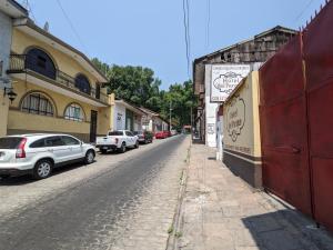 une rue avec des voitures garées sur le côté d'un bâtiment dans l'établissement Hotel del Parque, à Uruapan del Progreso