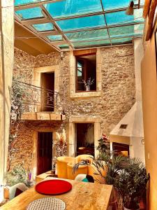 un patio avec une table et un bâtiment en pierre dans l'établissement La maison du Bougainvillier 10 personnes, à Dions