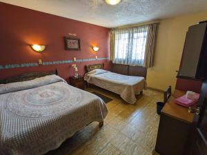 Cette chambre comprend 2 lits et une télévision. dans l'établissement Hotel del Parque, à Uruapan del Progreso