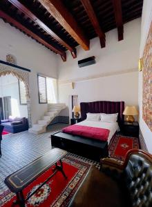 um quarto com uma cama grande e um cobertor vermelho em RiadLalZahra em Rabat