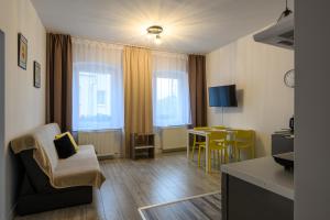 a living room with a couch and a table and chairs at Apartamenty Czary Mary in Bardo