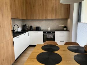 a kitchen with a wooden table and a kitchen with white cabinets at Widokowe Wzgórze - Sun&Sport in Szczyrk