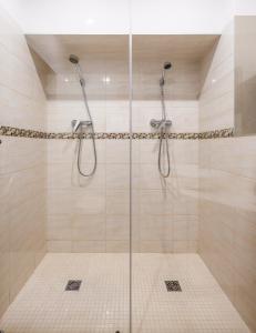 y baño con ducha y puerta de cristal. en Apartamenty Czary Mary en Bardo