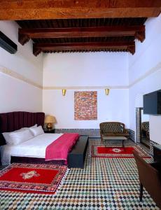 um quarto com uma cama e uma televisão num quarto em RiadLalZahra em Rabat