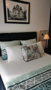 een bed met twee kussens en een foto aan de muur bij Green&Wood in Puck