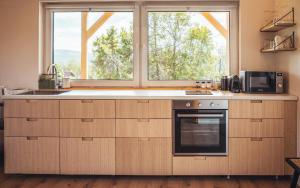 a kitchen with a stove and a window at Zebi vendégház in Zebegény +14 photos